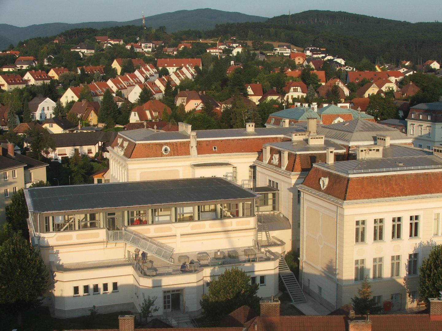Draufsicht auf den Gebäudekomplex der Mittelschule Berndorf mit einem modernen Dachaufbau und angrenzender Wohnsiedlung.